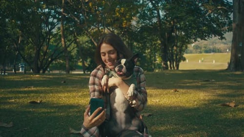 Woman Takes Selfie with Dog in City Park
