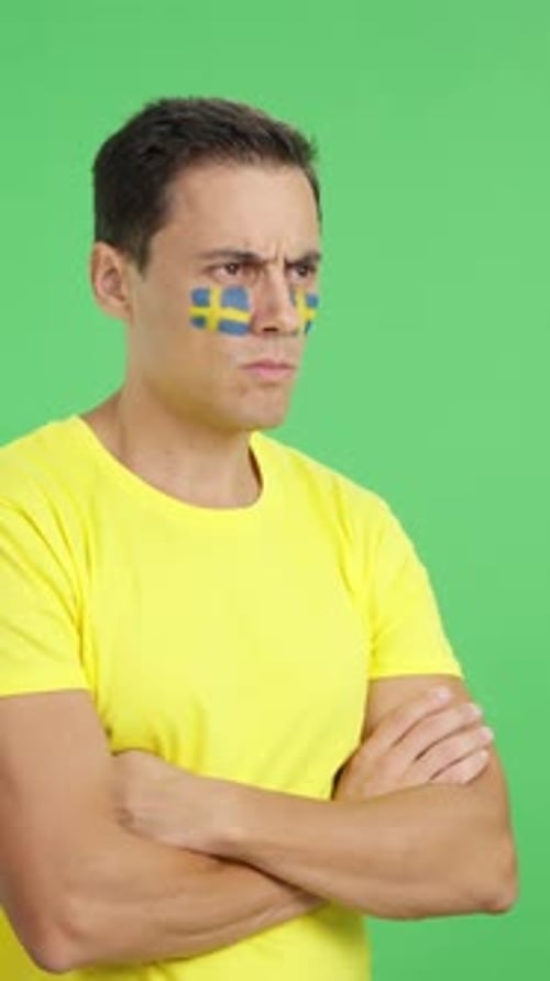 Man with Swedish Flag Painted Looking Away with Serious Expression