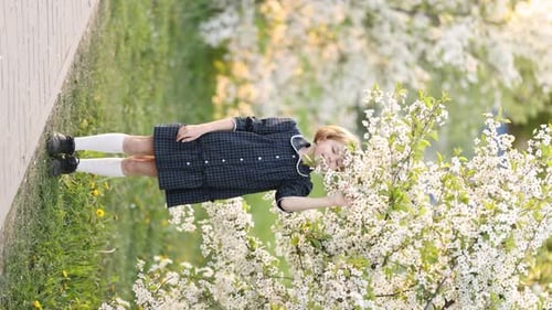 Girl in Blooming Apple Orchard