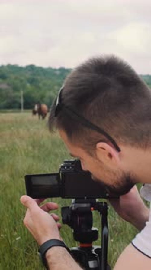Man Filming Woman Riding Horse in Grassy Field