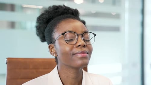 African american businesswoman relaxing with her eyes closed sitting at workplace in business office