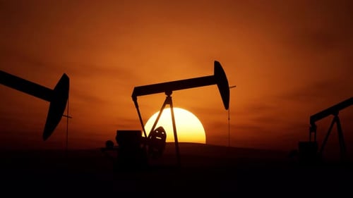 Pumpjacks Operate Against A Stunning Sunset Backdrop In Oil Production Area