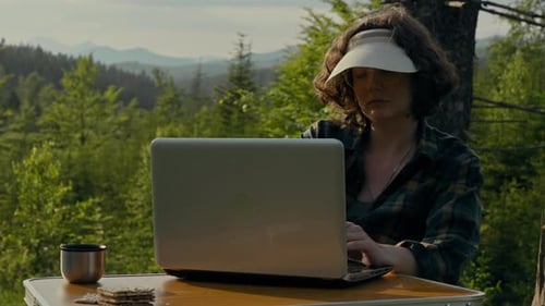 Tourist, A Middle Aged Man With Pleasure Works Remotely While Sitting In The Mountains Looking