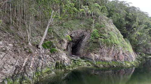 Cave by river with trees above drone,aerial