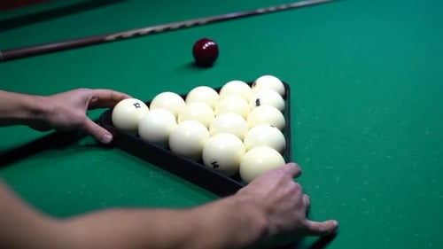 White billiard balls in the form of a triangle with numbers on a pool table