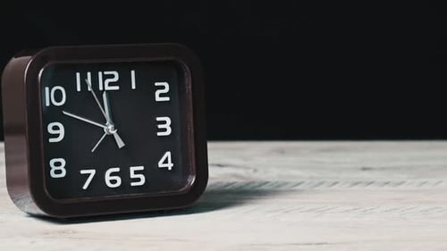 Analoguhr auf Holztisch und schwarzem Hintergrund Show Time