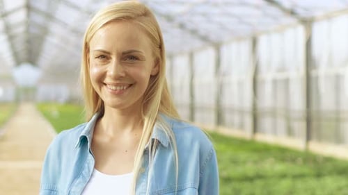 Smiling woman inside of greenhouse on flower farm