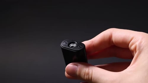 Woman with hidden camera on black background, closeup
