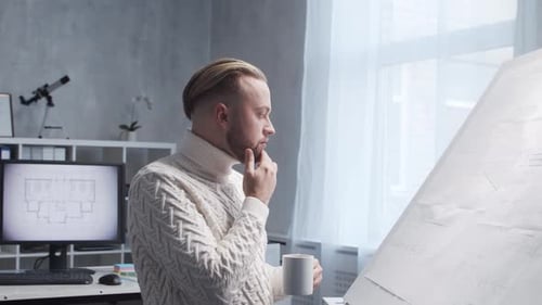 Konzentrierter Architekt arbeitet im Loft mit Zeichenbrett Arbeitsplatz eines jungen Ingenieurs in der Moderne