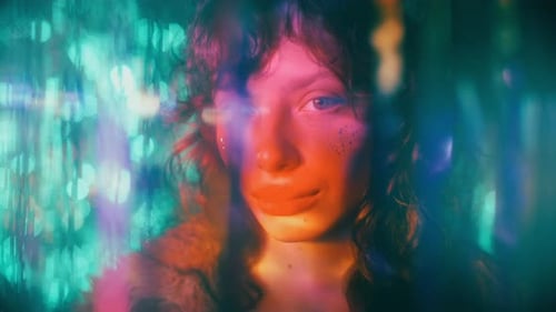 Beautiful Woman with Glitter Makeup Posing in Colorful Glowing Lights