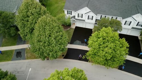 Workers Resurfacing Driveways in Suburban Neighborhood