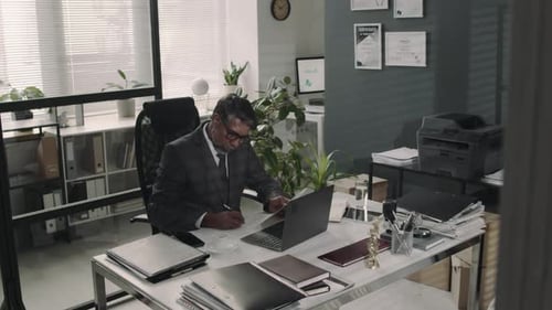 Senior Solicitor Working with Documents at Table in Law Firm