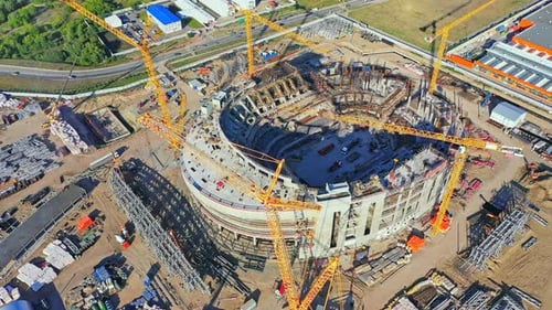 Las grúas de construcción montan la estructura de concreto del estadio