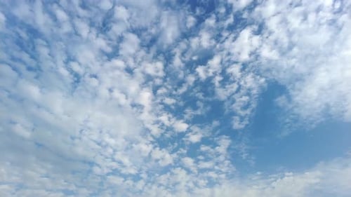 Fluffy White Clouds Drifting Across a Blue Sky