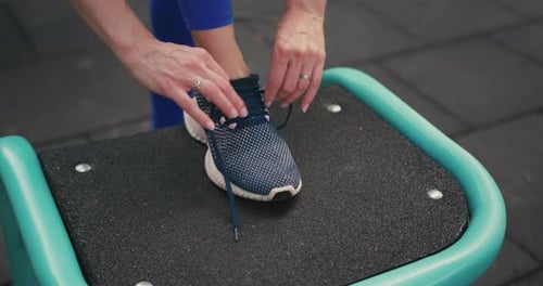 Adult Tying Running Shoe at Outdoor Exercise Area