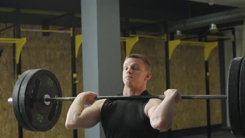 Strong man lifts weights in gym during workout session