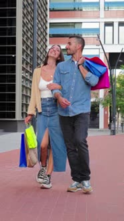 Happy Couple Walks with Shopping Bags in City