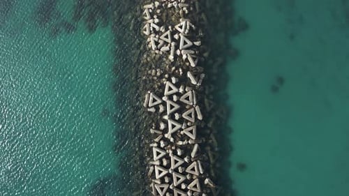 Breakwater Aerial view, Waves in ocean broken into clear water on other side