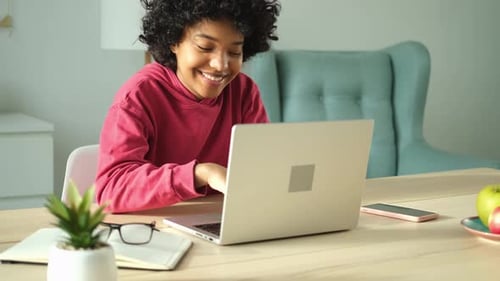 African American Girl Using Laptop at Home Office Looking at Screen Typing Chatting Reading Writing