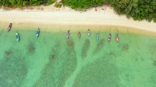 Boats near shore of island. Traditional colorful fishing vessels floating on calm blue water near wh