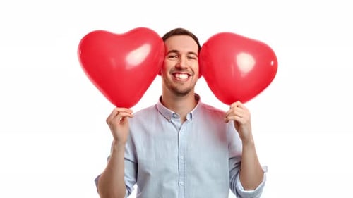 Smiling Man Holding Red Heart Shaped Balloons