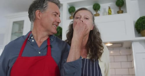 Couple Tasting Food Together in a Kitchen