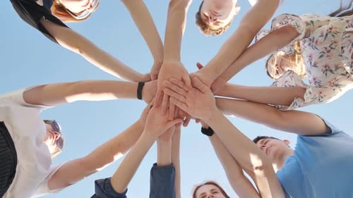 Youthful Team United with Hands Against Blue Sky