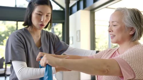 Woman Exercising with Physical Therapist Using Resistance Band