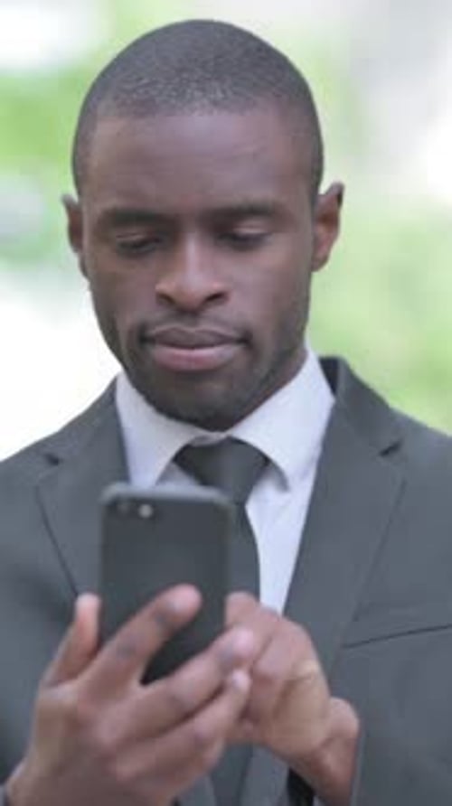 Young Adult Using Phone in Greenery, Close Up