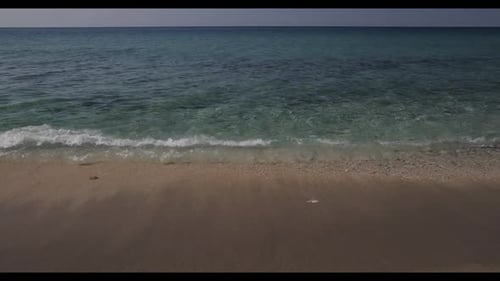 The beautiful sea waves gently crash onto the sandy beach.