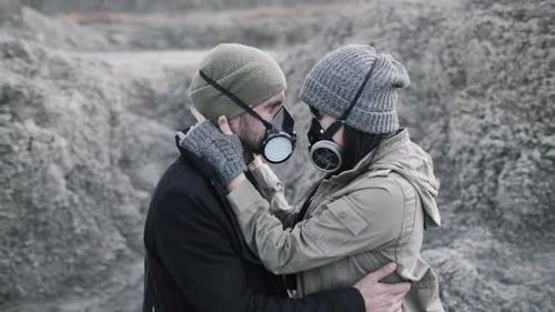 A Survivor Lovely Couple in Gas Mask Hugging on Desolate Out Forest Landscape