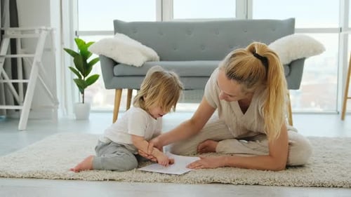 Child and Adult Drawing Together Indoors