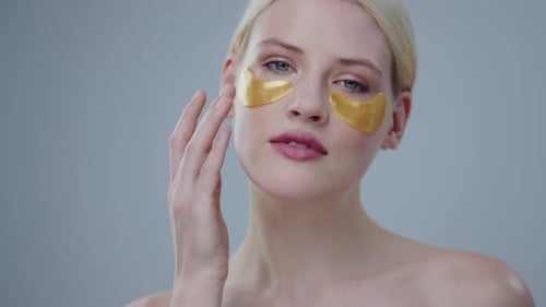 Young Woman Wearing Golden Eye Patches