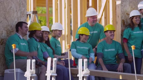 Diverse volunteers building a habitat for humanity house with teamwork and unity