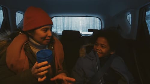 Woman and Child Talking in Car on Winter Road