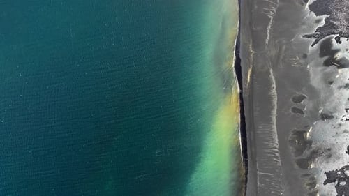 Black Beach in Iceland Aerial View Green Grass Grow From Black Sand Unearthly Landscape