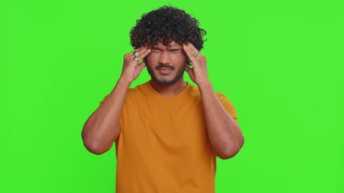 Man Rubs Temples, Shakes Head, Against Green Screen