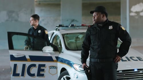 Close Up African American Young Man Cops Stand Near Patrol Car Look Around Background His Colleague