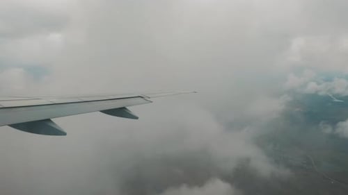 Ebenen, Berge aus der Höhe eines Flugzeugs, das in den Wolken fliegt