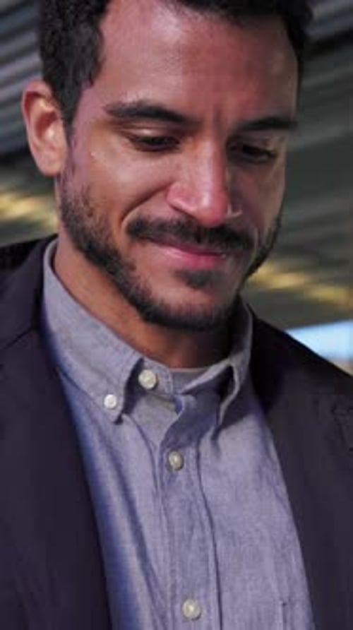 Smiling Young Man Using Smartphone in City Setting