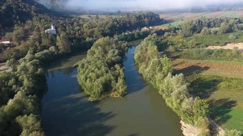 Aerial view of natural island covered with forest on a river by drone