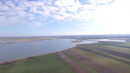 Aerial View of Fields and Lake on Sunny Day