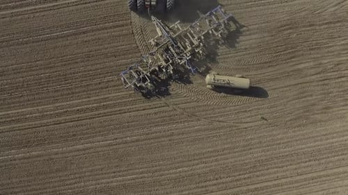 Big red tractor working on the field cultivating and applying nitrogen ASP