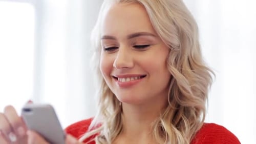 Smiling Woman Using Smartphone Indoors During the Day