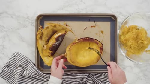 Preparing Roasted Spaghetti Squash Halves on Marble