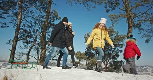 Happy Family with Sled in Winter Forest