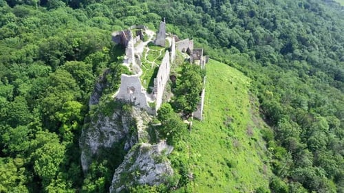 Flight above the abandoned and ruined medieval Plavecky Castle on a rock, Slovakia.