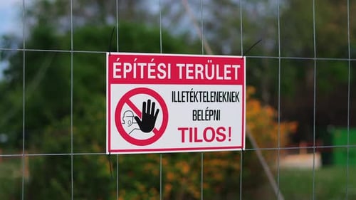 Letrero
húngaro de no entrar sin autorización colgado en una cerca. Fondo borroso