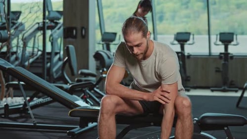 Footage of Young Man in Sportswear Drinking Water During Workout in Gym Indoors Male Athlete Looking