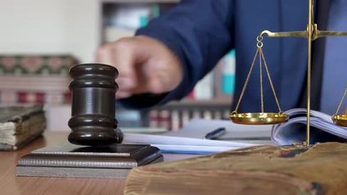 Working at a Desk Next to Scales of Justice